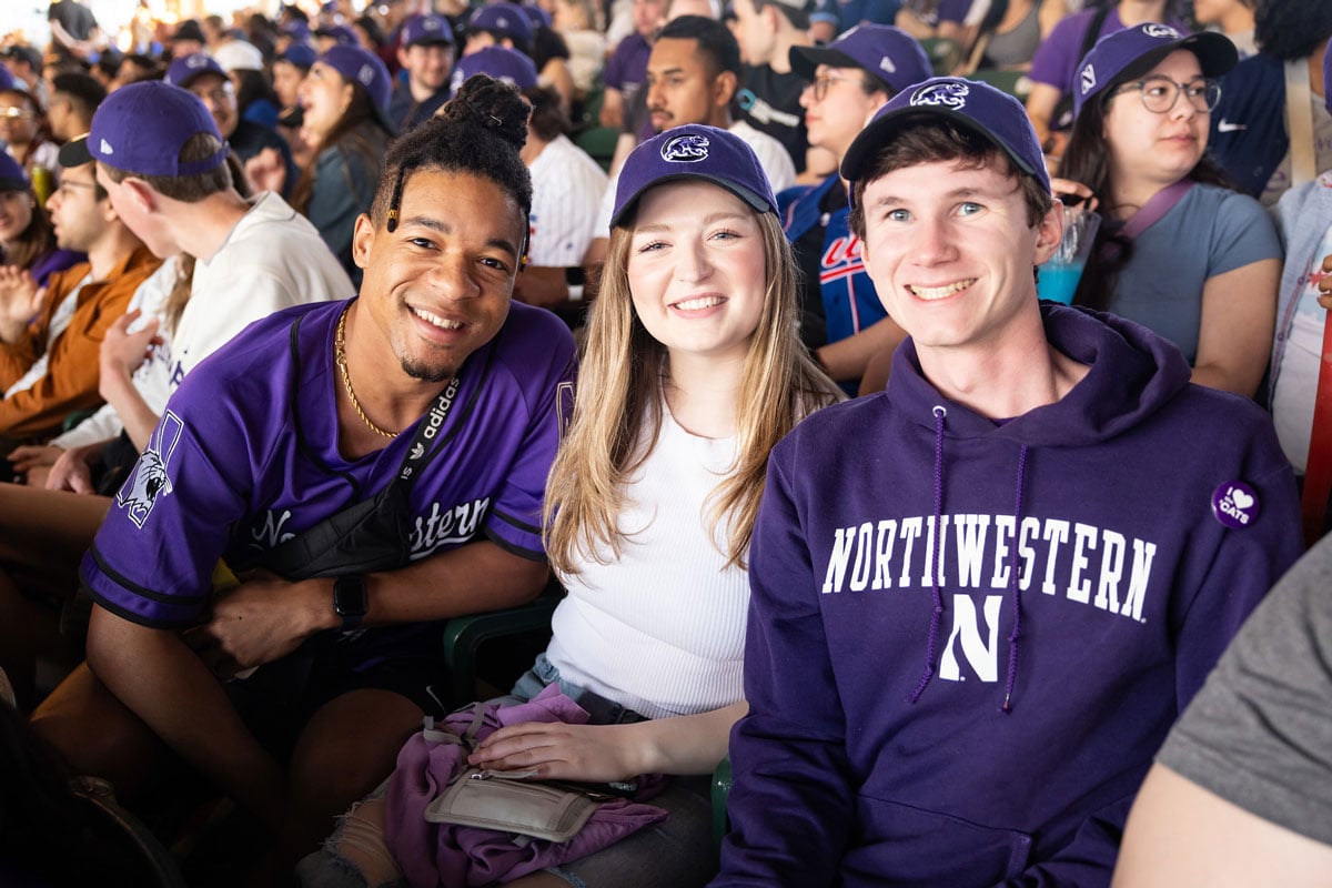 Students smiling at baseball game