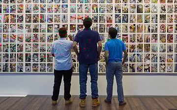 Men admiring a wall of art